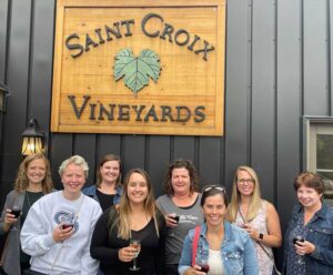 Group shot of employees in front of the Saint Croix Vineyard sign.