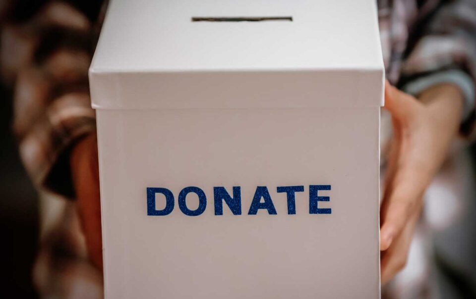 Close up of woman holding a donation box.