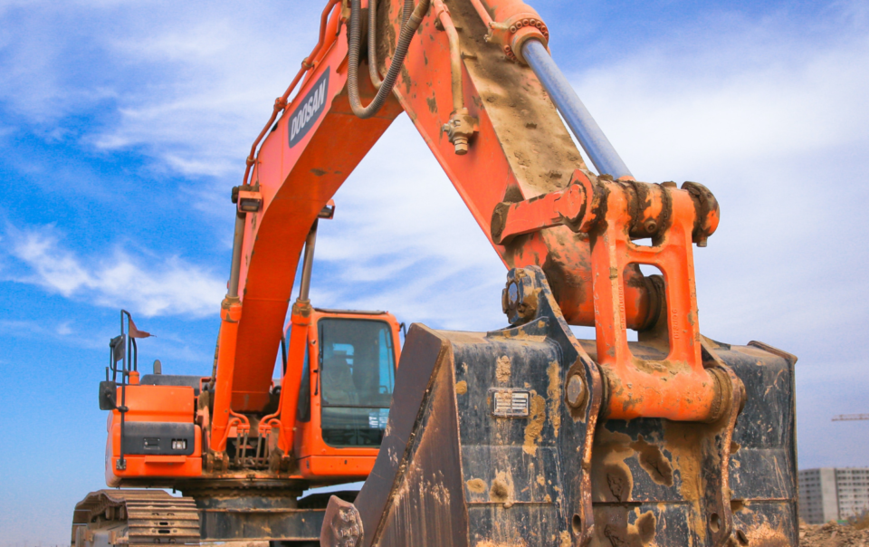 Low Angle Photography of Orange Excavator Under White Clouds