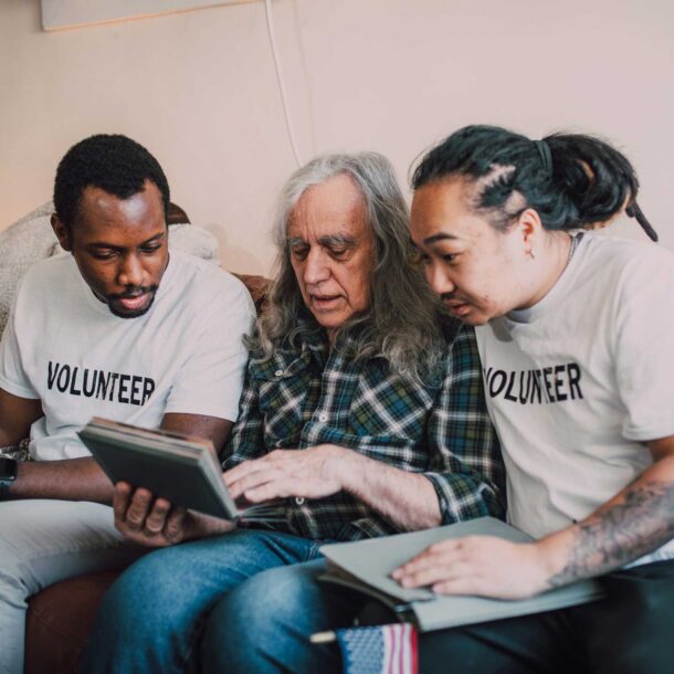 Volunteers looking at photo album with homeless person