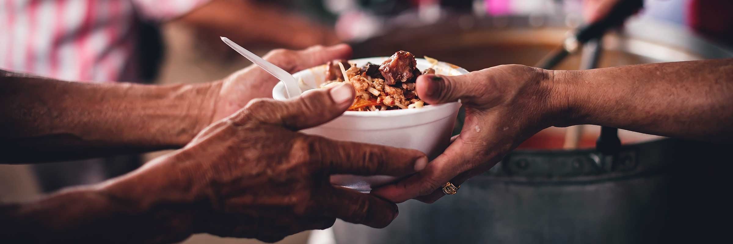 Volunteers handing out food to hungry people