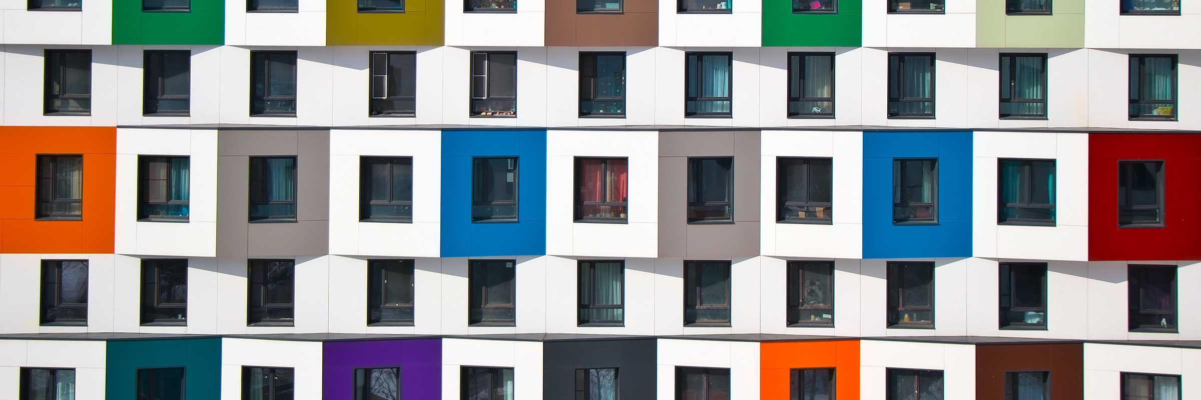 Front of apartment complex with bright abstract colored windows