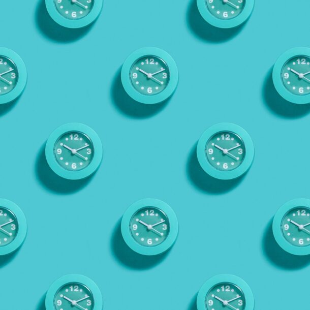 Image of multiple teal clocks evenly spread on solid teal background.