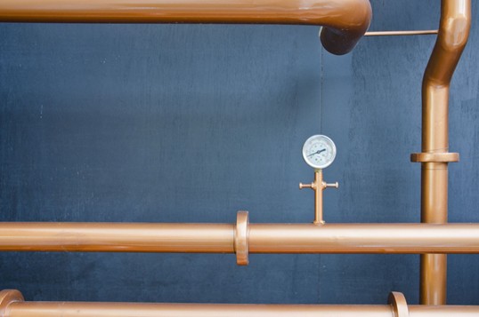 Photo of pipes cross each other with a meter.